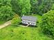 Aerial view of a home with mature trees and a well-maintained lawn and red shed at 7531 Linda Lake Dr, Charlotte, NC 28215