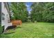 Spacious backyard with a wooden deck, lush lawn, and mature trees at 7531 Linda Lake Dr, Charlotte, NC 28215