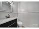 Bathroom vanity features modern light fixture, granite countertop, and white wainscotting at 7531 Linda Lake Dr, Charlotte, NC 28215