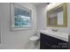 Bathroom featuring a window, vanity, toilet, mirror, and tile floor at 7531 Linda Lake Dr, Charlotte, NC 28215