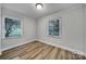 Cozy bedroom with wainscotting on the walls, wood-look floors, and bright windows at 7531 Linda Lake Dr, Charlotte, NC 28215