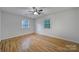 Bedroom with a ceiling fan, hardwood floors, and two windows for natural light at 7531 Linda Lake Dr, Charlotte, NC 28215