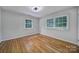 Bright bedroom boasts two windows, hardwood floors and neutral paint at 7531 Linda Lake Dr, Charlotte, NC 28215