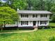 Charming two-story home with white brick, black shutters, and well-manicured front yard landscaping at 7531 Linda Lake Dr, Charlotte, NC 28215