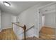 Stairwell leading to a hallway with wood-look floors and white doors at 7531 Linda Lake Dr, Charlotte, NC 28215