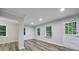 Bright room with new wood-look flooring, white trim, and many windows at 7531 Linda Lake Dr, Charlotte, NC 28215