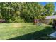 Spacious backyard with lush green grass, mature trees, a play set, and a picnic table for outdoor fun at 806 Mcgregor Ne Dr, Concord, NC 28025