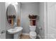 Cozy bathroom featuring a pedestal sink, toilet, and decorative elements at 806 Mcgregor Ne Dr, Concord, NC 28025