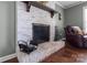 Living room fireplace with white brick and a decorative wooden mantel at 806 Mcgregor Ne Dr, Concord, NC 28025
