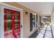 Elegant red front door with decorative glass and a covered porch featuring rocking chairs at 806 Mcgregor Ne Dr, Concord, NC 28025