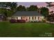 Charming single-story home with a well-manicured lawn, covered porch, and traditional American flag at 806 Mcgregor Ne Dr, Concord, NC 28025