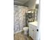 This well-lit bathroom has a shower with marble-look curtain, vanity, shelving, and tile floors at 854 Silver Fox Dr, Concord, NC 28025