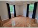 Bright bedroom with hardwood floors, complemented by natural light from two windows with dark curtains at 854 Silver Fox Dr, Concord, NC 28025