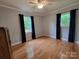 Bright bedroom with hardwood floors, complemented by natural light from two windows with dark curtains at 854 Silver Fox Dr, Concord, NC 28025