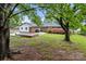 Well-maintained backyard featuring a concrete patio and vibrant blooming shrubs and mature trees at 101 Wynnchester Rd, Gastonia, NC 28056