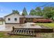 Expansive backyard with a concrete patio, retaining wall, and mature landscaping, creating a serene outdoor space at 101 Wynnchester Rd, Gastonia, NC 28056