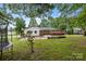 Backyard with a basketball area, grassy lawn, and a vibrant display of flowering bushes at 101 Wynnchester Rd, Gastonia, NC 28056