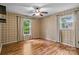 Empty bedroom with hardwood floors, two windows, ceiling fan, and plaid wallpaper at 101 Wynnchester Rd, Gastonia, NC 28056
