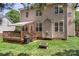 A backyard featuring a wooden deck with awning, grill, fire pit, and lush green grass at 1011 Master Gunner Ct, Indian Trail, NC 28079