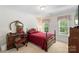 Cozy bedroom with a decorative four-poster bed, desk, and ample natural light at 1011 Master Gunner Ct, Indian Trail, NC 28079