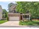 Two-story brick and siding home with an attached garage, covered front porch, and manicured lawn at 1011 Master Gunner Ct, Indian Trail, NC 28079