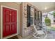 Inviting front porch with rocking chairs, red door, and brick accents at 1011 Master Gunner Ct, Indian Trail, NC 28079