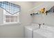 Bright laundry room with white washer and dryer and plenty of shelving space for storage at 1011 Master Gunner Ct, Indian Trail, NC 28079