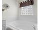 A luxurious soaking tub with tiled surround and decorative privacy window at 1011 Master Gunner Ct, Indian Trail, NC 28079