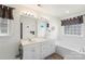 Bright primary bathroom featuring double sinks, soaking tub, and walk-in shower at 1011 Master Gunner Ct, Indian Trail, NC 28079