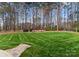 Expansive backyard with lush lawn, bordered by mature trees, creating a serene and private outdoor space at 107 Waterhouse Ct, Mooresville, NC 28117