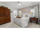 Cozy bedroom featuring a statement floral wallpaper, hardwood furniture, and bright natural light at 107 Waterhouse Ct, Mooresville, NC 28117