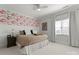 Bright bedroom features a floral accent wall, window and a comfortable bed at 107 Waterhouse Ct, Mooresville, NC 28117