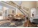 Comfortable living room with staircase, large windows, and inviting sofas at 107 Waterhouse Ct, Mooresville, NC 28117