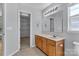 Bathroom featuring a wooden vanity, large mirror, and a doorway into a walk-in closet at 1218 Faversham Ln, Rock Hill, SC 29730