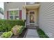 Charming home entrance with a storm door, manicured landscaping, and neutral siding at 1218 Faversham Ln, Rock Hill, SC 29730