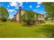 View of backyard with screened-in porch, mature trees, and well-kept lawn at 1260 Summer Ln, Salisbury, NC 28146