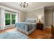 Well lit bedroom with hardwood floors, decorative rug, and a large window at 174 Buffalo Creek Dr, Statesville, NC 28677