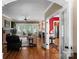 Spacious living room with hardwood floors, a brick fireplace, and a view of the dining room at 174 Buffalo Creek Dr, Statesville, NC 28677