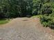 Large gravel parking area surrounded by mature trees and natural landscaping at 174 Buffalo Creek Dr, Statesville, NC 28677