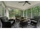 Cozy screened porch with wicker furniture, ceiling fan, and views of a lush green yard at 174 Buffalo Creek Dr, Statesville, NC 28677