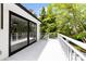 Bright white deck with black framed sliding glass doors and classic white railings overlooks lush green trees at 200 Kimrod Ln, Charlotte, NC 28270