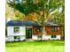 Charming exterior featuring manicured lawn, black framed windows, wood and white accents and mature trees at 200 Kimrod Ln, Charlotte, NC 28270