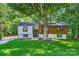 Stunning updated split level home boasts a striking facade with modern siding, black trim windows, and lush landscaping at 200 Kimrod Ln, Charlotte, NC 28270