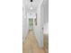 Long hallway with neutral paint, light wood floors, modern light fixtures, and white doors at 200 Kimrod Ln, Charlotte, NC 28270