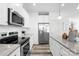 Well-equipped kitchen with stainless steel appliances, white cabinets, granite countertops, and wood-look floors at 2123 Gemway Dr, Charlotte, NC 28216