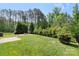 Lush backyard with mature trees and a cozy fire pit area, perfect for entertaining and relaxing outdoors at 2214 Laurens Dr, Concord, NC 28027