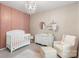 A darling Bedroom with a white crib, changing table, chair, and chandelier offers a serene setting at 2214 Laurens Dr, Concord, NC 28027
