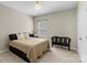 Neutral bedroom with a queen bed, bench, and a window provides a relaxing ambiance at 2214 Laurens Dr, Concord, NC 28027