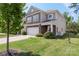 Charming two-story home featuring stone accents, attached garage, and lush green lawn at 2214 Laurens Dr, Concord, NC 28027
