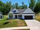 Inviting single-Gathering home featuring a pristine white facade, dark shutters, and a convenient two-car garage at 2567 Cornelius Nw Pl, Concord, NC 28027